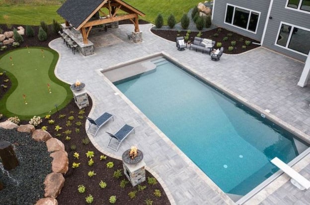 a backyard with pool, pergula, and mini golf course