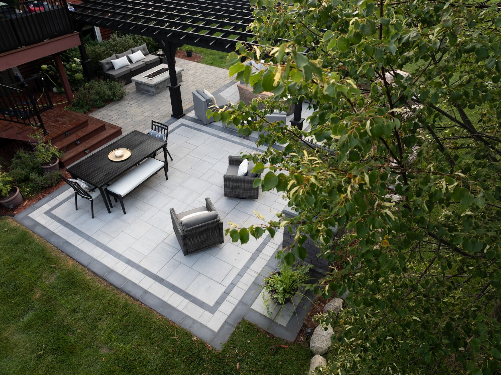 a backyard with a hardscaped paver surrounded by plants