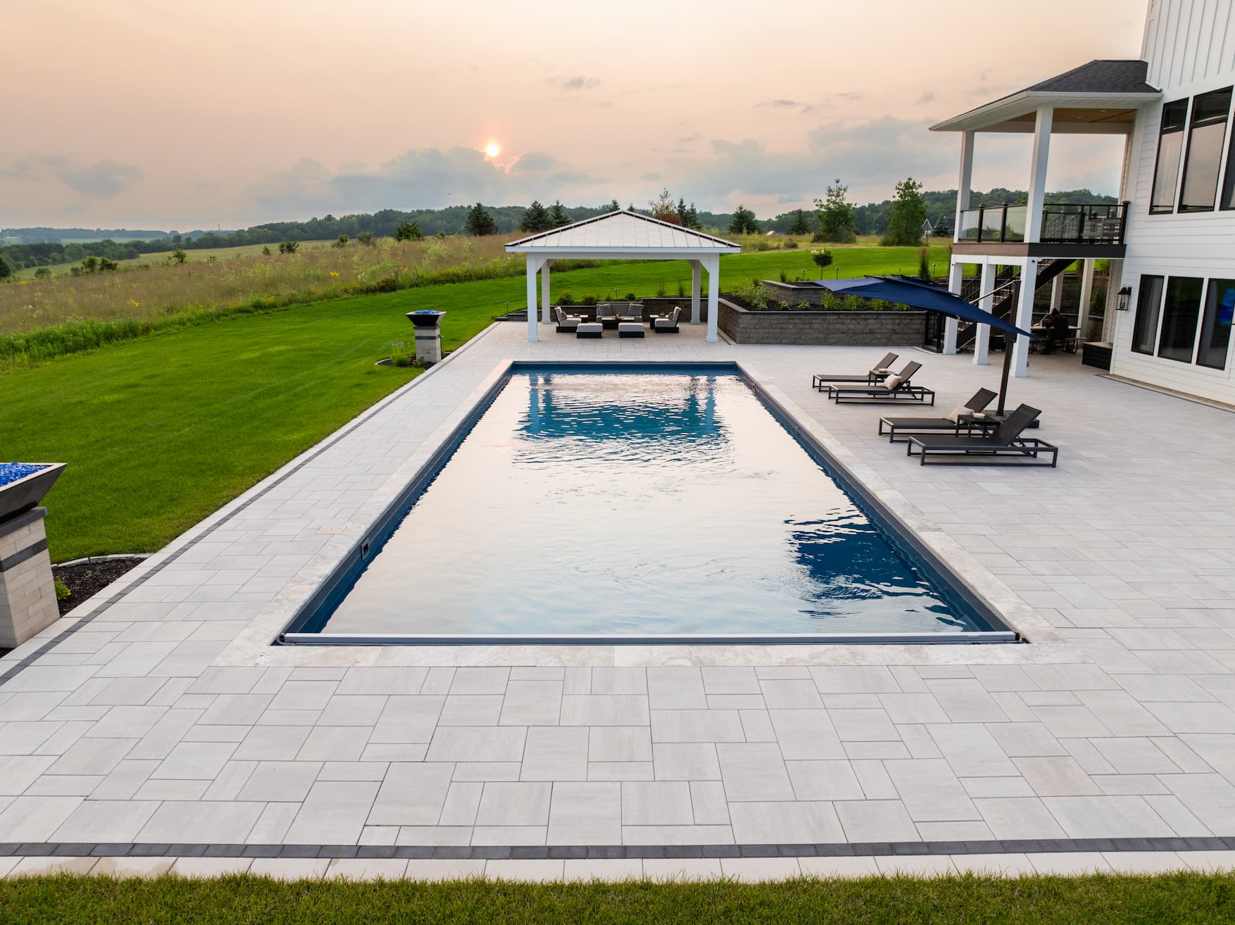 an in-ground pool illumiated by the sunset.