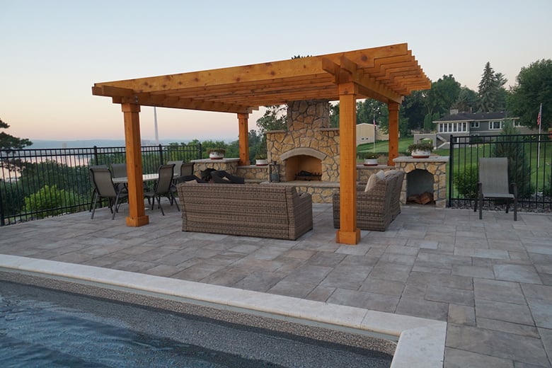a warm wooden pergola over an outdoor fireplace