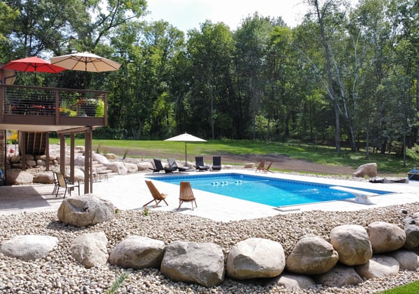 an inground pool surrounded by small stones