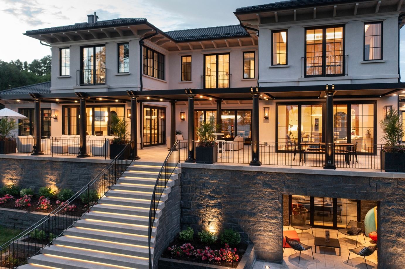 close up view of a luxurious mansion, with a wraparound porch