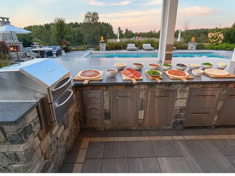 an outdoor kitchen setup with pizza toppings to make your own pizzas