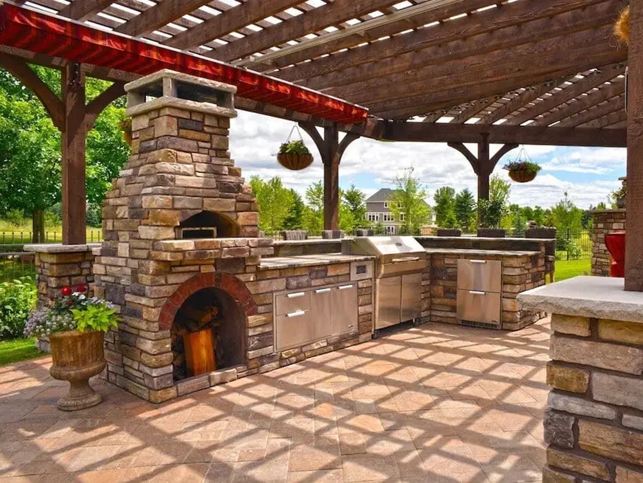 An outdoor kitchen under a wood pergola