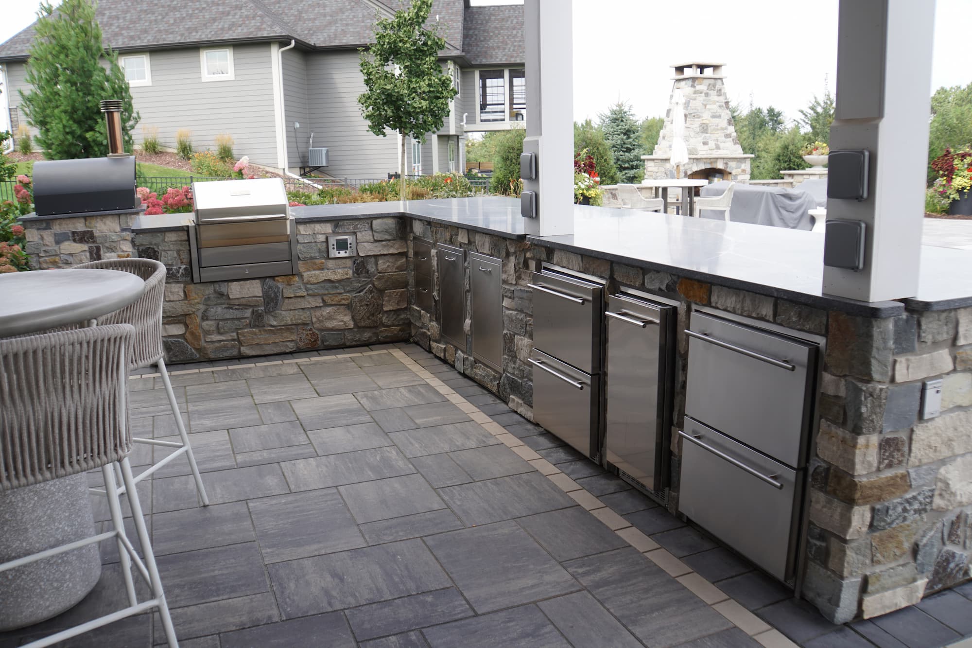an outdoor kitchen space with integrated appliances into bespoke stonework.