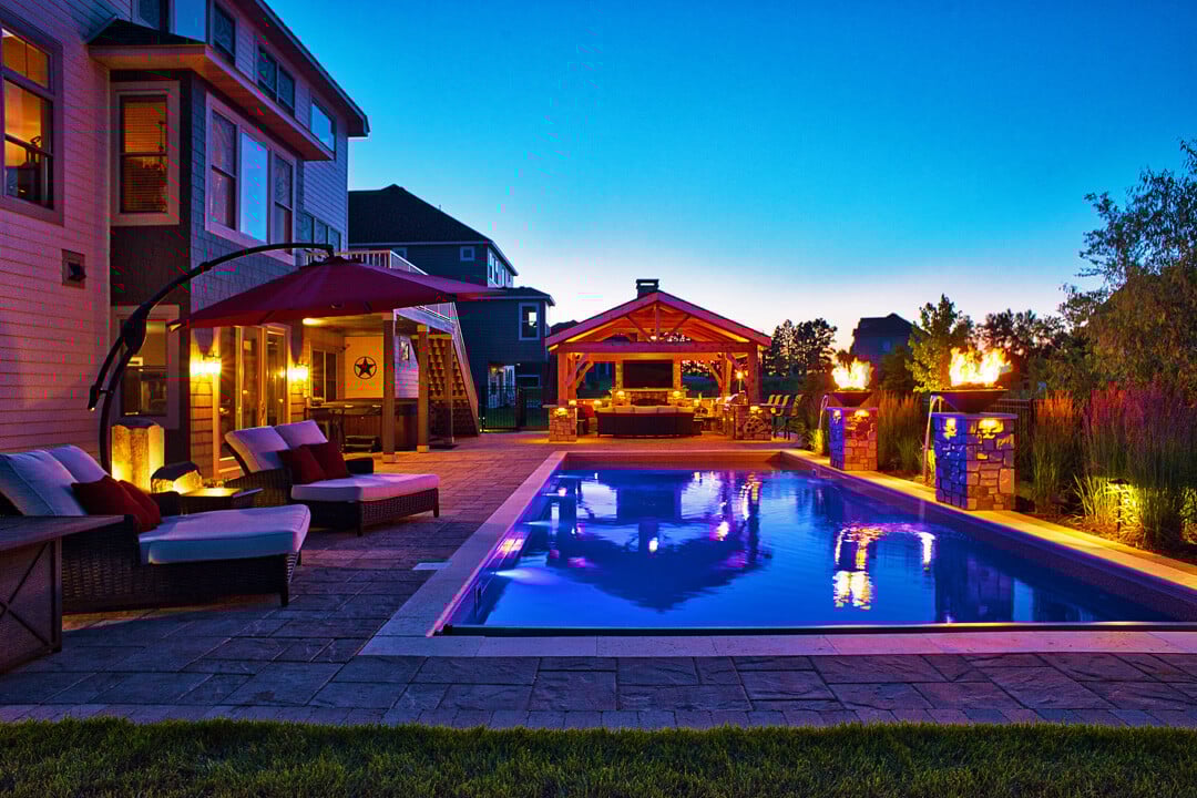 a pool at night surrounded by torches.