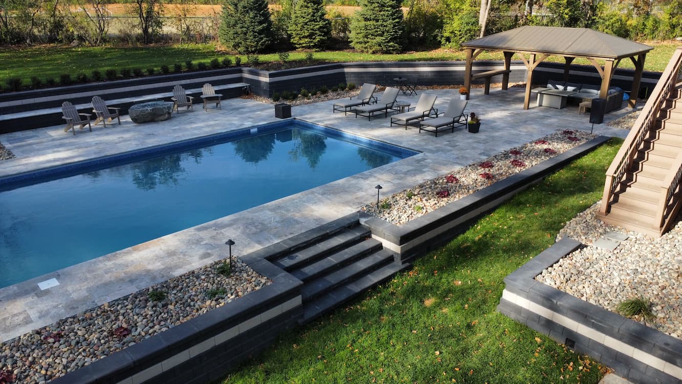 a series of retaining walls and rock gardens surrounding an in-ground pool