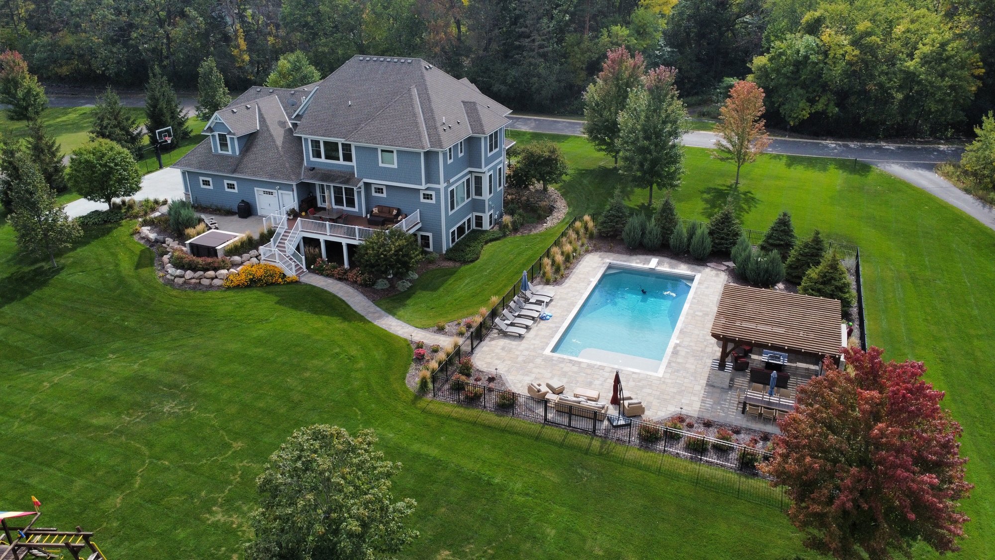 an overview of a backyard with a pool and large stone retaining walls