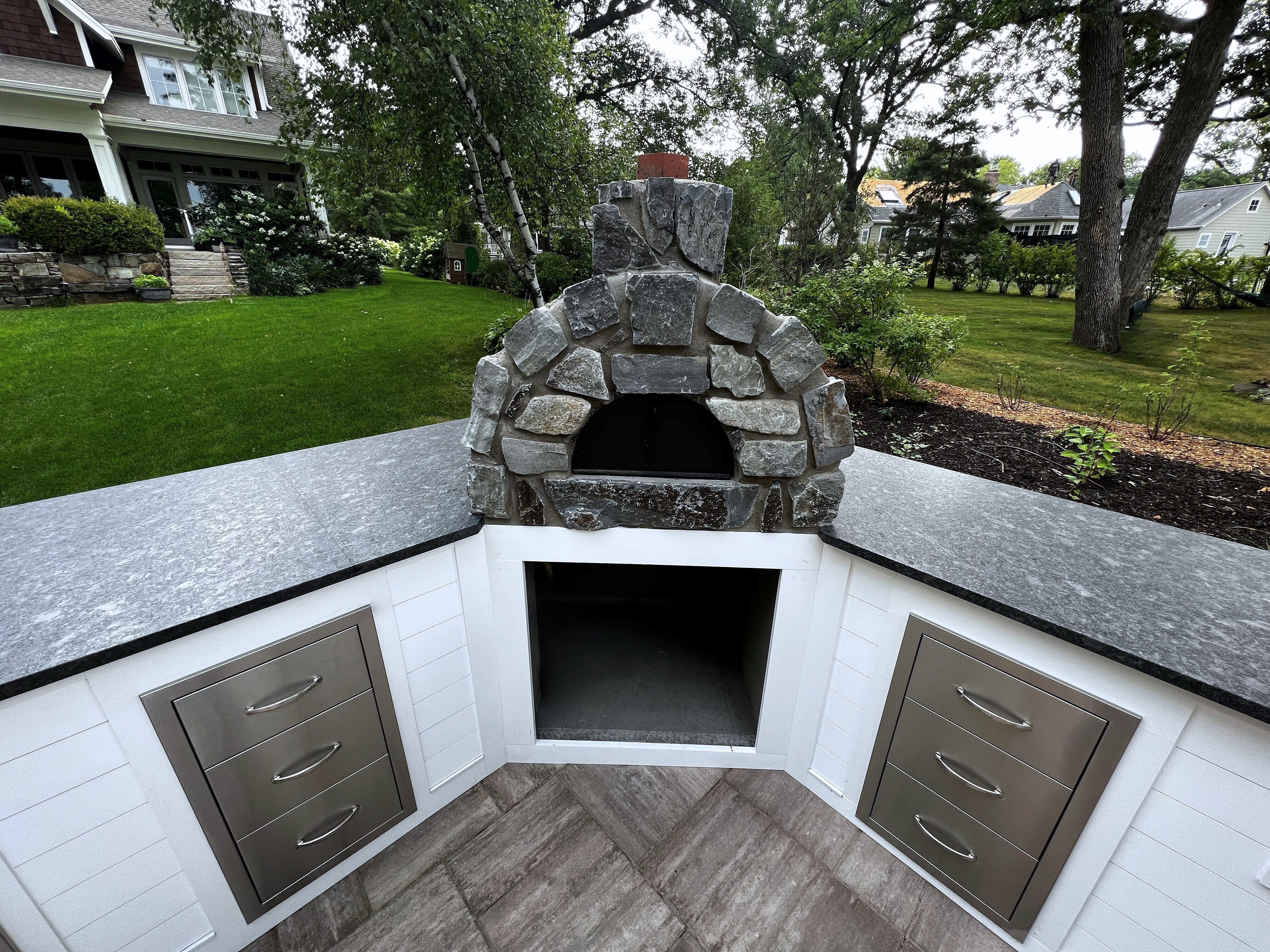 A wood stove outdoors on a white cabinet